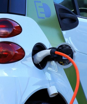 Close-up of an electric car being charged, highlighting eco-friendly transportation.