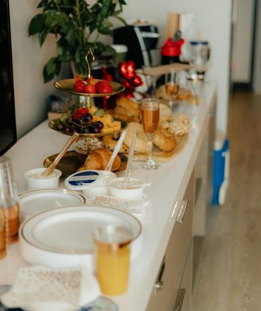 Beautifully arranged table with pastries, fruits, and flowers for an elegant brunch setting.