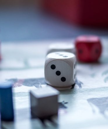 Close-up view of board game pieces and dice on a game board. Perfect for recreation and strategy themes.